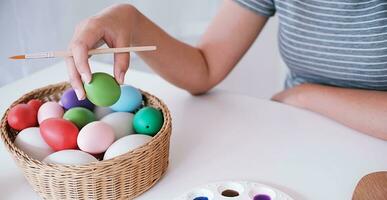 Woman painting Easter eggs at home. family preparing for Easter. Hands of a girl with a easter egg photo