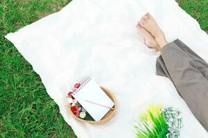 woman alone resting on a picnic in nature park outside at sunny day  enjoying summertime and dreaming photo