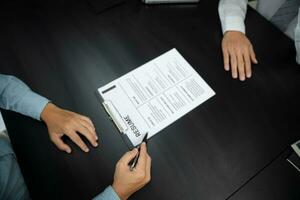 Examiner reading a resume during job interview at office Business and human resources concept. photo