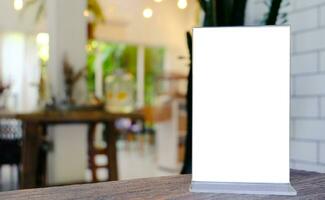 Mock up Menu frame standing on wood table in Bar restaurant cafe. space for text photo