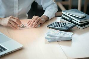 Businesswoman analyzing investment charts and pressing calculator buttons over documents. Accounting Concept. photo