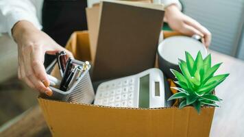 Business woman sending resignation letter and packing Stuff Resign Depress or carrying business cardboard box by desk in office. Change of job or fired from company photo