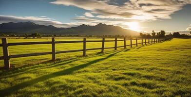 Green grass field, wooden Fence and mountain on horizon at summer morning. Generative AI photo