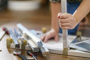 Asian Woman self repairs furniture renovation using equipment to diy repairing furniture sitting on the floor at home photo