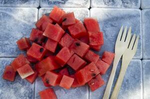 a fork and knife sitting on a pile of watermelon photo