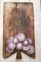 a knife and a bunch of onions on a cutting board photo