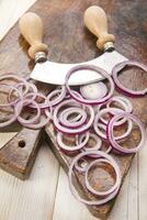 a knife and a bunch of onions on a cutting board photo