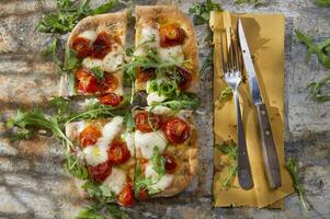 pizza con tomate y rúcula foto