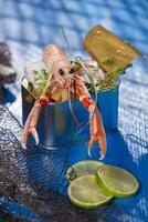 a shrimp in a container with a lime on a blue table photo