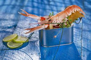 a shrimp in a container with a lime on a blue table photo