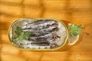 fresh herring in a tin on a wooden table photo