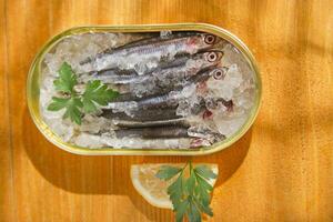 fresh herring in a tin on a wooden table photo