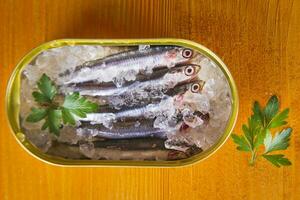 fresh herring in a tin on a wooden table photo