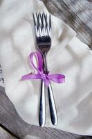 a pair of forks and a napkin tied with a ribbon photo