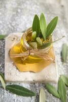 Small glass jar containing olive oil photo