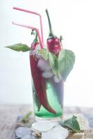 a glass filled with green and red peppers photo