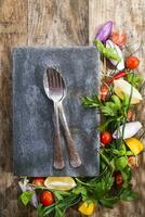 a plate with a fork and knife sitting on top of a wooden table photo