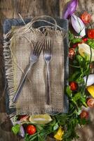 a plate with a fork and knife sitting on top of a wooden table photo