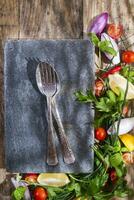 a plate with a fork and knife sitting on top of a wooden table photo