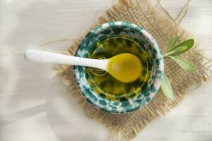 Small container with extra virgin olive oil photo