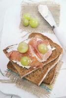 Bread, cheese and ham and grapes photo