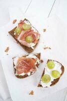 Bread, cheese and ham and grapes photo