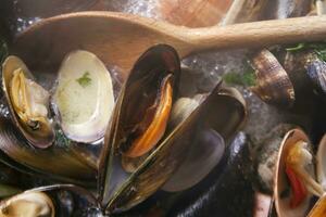 un cuenco de mejillones con limón y perejil foto