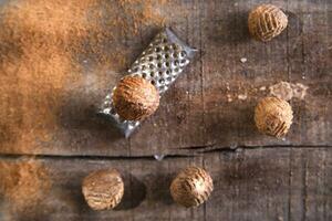 un rallador con nueces en un de madera superficie foto