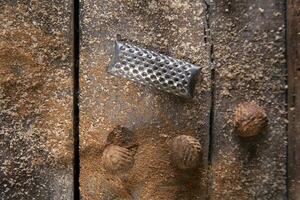 a grater with nuts on a wooden surface photo