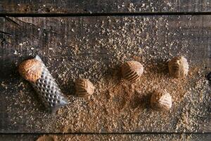 a grater with nuts on a wooden surface photo