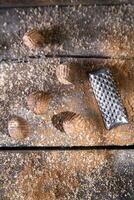 a grater with nuts on a wooden surface photo