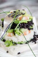 Tower of black and white rice with shrimp and zucchini photo