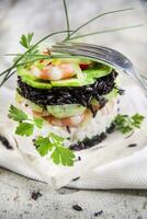 Tower of black and white rice with shrimp and zucchini photo