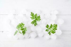 a pile of ice cubes with parsley leaves on top photo