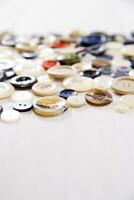 a pile of buttons on a white table photo