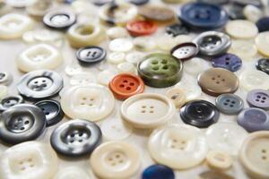 a pile of buttons on a white table photo