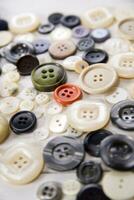 a pile of buttons on a white table photo