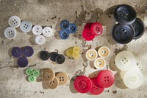 sewing supplies and buttons arranged on a white surface photo