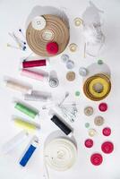sewing supplies and buttons arranged on a white surface photo