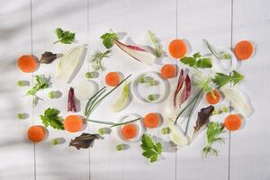 a white table with carrots, onions, celery and parsley photo