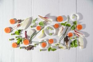 a white table with carrots, onions, celery and parsley photo