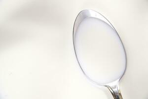 two spoons on a white plate with milk photo