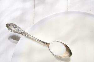 two spoons on a white plate with milk photo