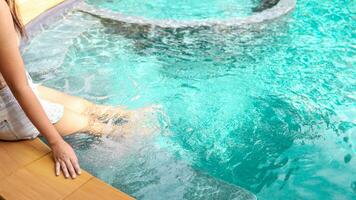 Young asian Beautiful woman relaxing in swimming pool at spa resort. Beautiful tropical beach front hotel resort with swimming pool photo