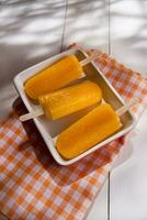 ice pops on a plate with orange and green stripes photo