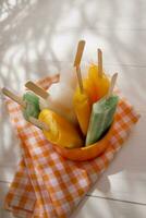 ice pops on a plate with orange and green stripes photo