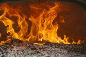 un cerca arriba de un fuego ardiente en un madera ardiente horno foto