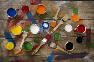 un mesa con pintar latas y cepillos foto