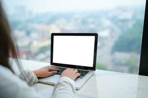 Woman Working by using laptop blank screen computer . Hands typing on a keyboard.technology e-commerce concept. photo