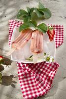 a plate with two popsicles on it and strawberries photo